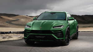 綠色藍寶堅尼 Urus Performante 停在暴風雲下的沙漠觀景點。 — 蘭博基尼 壁紙