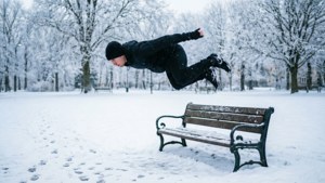 人跳過雪覆蓋的長椅（冬季公園）