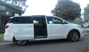 白色小型貨車，側門打開，停在街上，附近有樹木和建築物。 — 起亞 壁紙