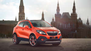 橙色Opel Mokka 7 SUV在歷史悠久的俄羅斯建築前。 — 歐寶 壁紙