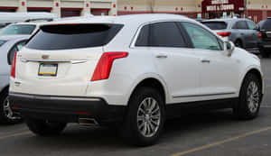 白色Cadillac XT5 SUV停放在商業停車場。 — Pro Display XDR 壁紙