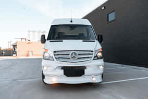 白色 Mercedes-Benz Sprinter 客貨車停放在城市混凝土停車場，靠近磚砌建築。 — Mercedes Benz C300 壁紙