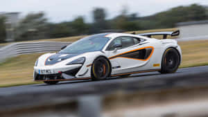 白色McLaren賽車在賽道上疾馳，帶有動態模糊效果。 — 4K 法拉利 壁紙