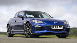 藍色馬自達RX-8跑車停泊在路上，背景有山丘。 — 馬自達 壁紙