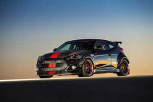日落時分沙漠公路上的黑色現代Veloster N甩尾車，帶有紅色點綴。 — Surface Pro 壁紙
