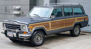灰色經典Jeep Wagoneer配備木紋飾板，停在城市人行道上。 — 老福特卡車 壁紙