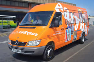 橙色EasyBus客貨車停泊在巴士站，司機可見。 — Mercedes Benz C300 壁紙