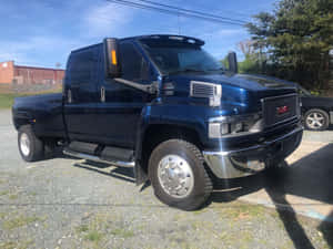 日落時分，深藍色GMC Sierra 4500雙排座貨車停泊在碎石場上。 — 卡車 壁紙