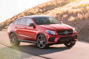日落時分，紅色Mercedes-AMG GLE Coupe在蜿蜒的山路上。 — Mercedes-Benz 壁紙