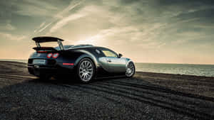 日落時分海邊礫石灘上的黑色Bugatti Veyron — 布加迪 GIF 壁紙
