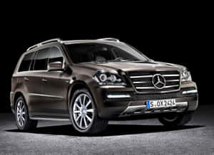 在深色地板上的攝影棚燈光中，一輛青銅色 Mercedes-Benz GL SUV。 — Mercedes-Benz 壁紙