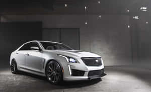 在燈光昏暗的工業倉庫中，聚光燈下的銀色Cadillac ATS-V跑車。 — Steam Deck OLED 壁紙