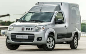 銀色 Fiat Novo Fiorino 商用廂型車停放在鋪砌場地上。 — Steam Deck 壁紙
