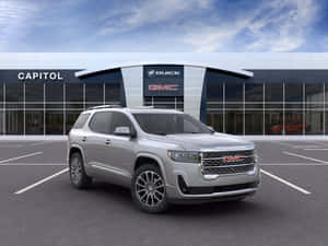 陽光明媚的日子裡，銀色GMC Acadia SUV停在Buick GMC經銷商處。 — 4:3 壁紙