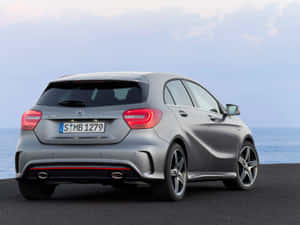 日落時分，銀色 Mercedes A45 AMG 停在海洋旁邊。 — Mercedes-Benz 壁紙