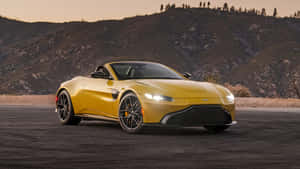 日落時分，黃色Aston Martin Vantage敞篷車停在山路上。 — 奧斯頓馬丁 壁紙