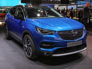 藍色Opel Grandland X SUV在車展上展出，背景有人群。 — 歐寶 壁紙