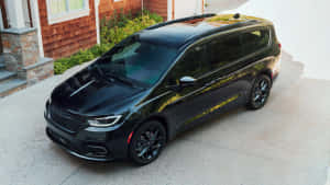 黑色小型貨車帶金色點綴停在房子前面。 — 奧迪 GIF 壁紙