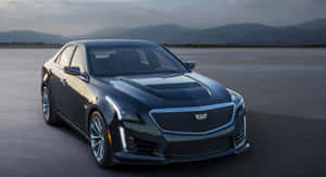 黑色Cadillac CTS-V轎車在黃昏時停放在混凝土上，背景是山脈。 — 凱迪拉克 壁紙