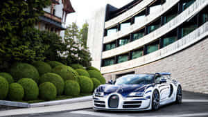 一台藍銀色Bugatti Veyron停放在綠色樹籬和現代建築旁邊。 — 布加迪 GIF 壁紙
