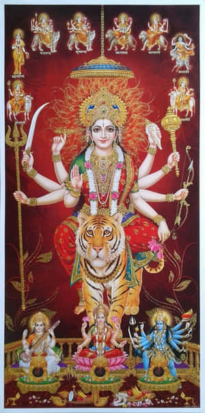 印度教女神杜爾迦多臂騎虎，周圍有其他神祇，場景裝飾華麗。 — Maa Durga 壁紙
