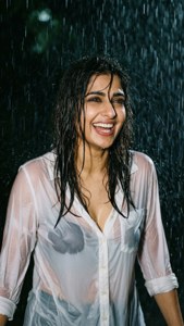 女性在雨中大笑，濕髮濕衫。