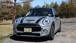 銀色MINI Cooper S帶黑色條紋停在樹旁的碎石上。 — 秋季 壁紙
