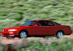 紅色跑車在綠色景觀中的泥土路上疾馳。 — Acura 壁紙