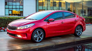 日落時，紅色Kia轎車停放在玻璃建築前的水景附近。 — 起亞 壁紙