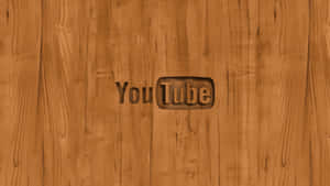 YouTube 標誌雕刻在木質表面上，可見木紋。 — 木質紋理 壁紙