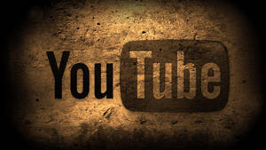 粗糙混凝土牆上的 YouTube 標誌，帶有聚光燈和暗邊。 — 音樂 壁紙