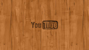 YouTube 標誌嵌入木質表面，木紋清晰可見。 — 社群 壁紙