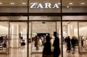 顧客進出設有玻璃門及明亮室內燈光的 Zara 服裝店。 — Zara 壁紙