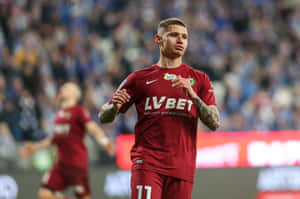 紅色球衣的足球運動員在夜間比賽中奔跑，身後有群眾。 — Cristiano Ronaldo 足球 壁紙
