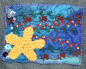 手工紡織品，帶有鉤針編織海星和珠子藤蔓，置於藍色布料上。 — Stitch 壁紙
