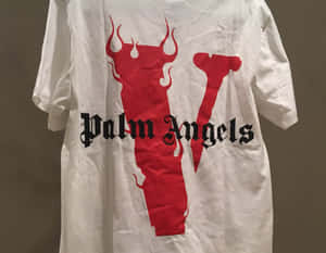 白色T恤，帶有紅色惡魔角 V 標誌和黑色 Palm Angels 文字。 — Vlone 壁紙