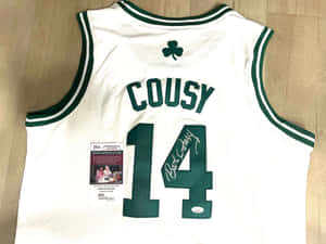 Bob Cousy簽名塞爾提克球衣，附JSA認證，置於木地板上。 — 運動 壁紙