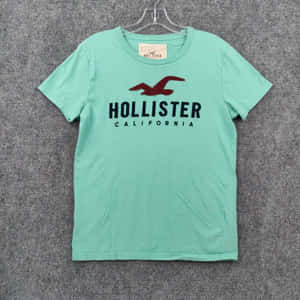 薄荷綠色Hollister T恤，紅色海鷗標誌，掛在衣架上。