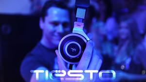 DJ Tiesto在音樂會上舉起發光的AKG耳機。 — 提雅斯多 壁紙