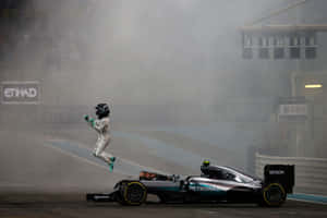 F1車手在煙霧瀰漫的賽道上，在其梅賽德斯賽車旁高興地跳躍。 — F1 2019 壁紙