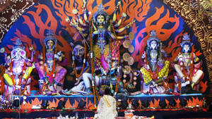 一個人在印度教節日期間崇拜一個大型多彩的杜爾迦神像。 — Maa Durga 壁紙
