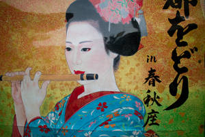穿著藍色花卉和服的藝妓在日式書法背景下吹奏竹笛。 — 日式 壁紙