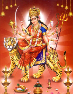 女神杜爾迦騎著老虎，手持武器和供品，置身於鮮紅的場景中。 — Maa Durga 壁紙