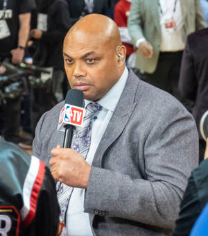 NBA TV體育記者穿著灰色西裝，在直播中手持麥克風。 — 運動 壁紙