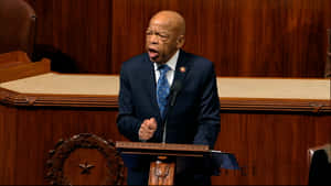 一位穿西裝的男士在立法會議廳的木製講台上熱情演講。 — 政治 壁紙