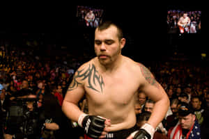 刺青及戴手套的MMA拳擊手站在場館內歡呼的人群前。 — 運動 壁紙