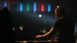DJ在音樂會上表演，舞台燈光色彩繽紛。 — 提雅斯多 壁紙