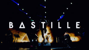 Bastille 樂隊在燈光璀璨的舞台上表演，剪影音樂家和發光的燈光。