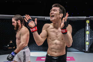 MMA拳手在擊敗對手後於八角籠中慶祝勝利。 — 運動 壁紙
