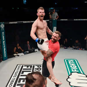 MMA拳手在八角籠內被教練舉起（勝利後） — 運動 壁紙